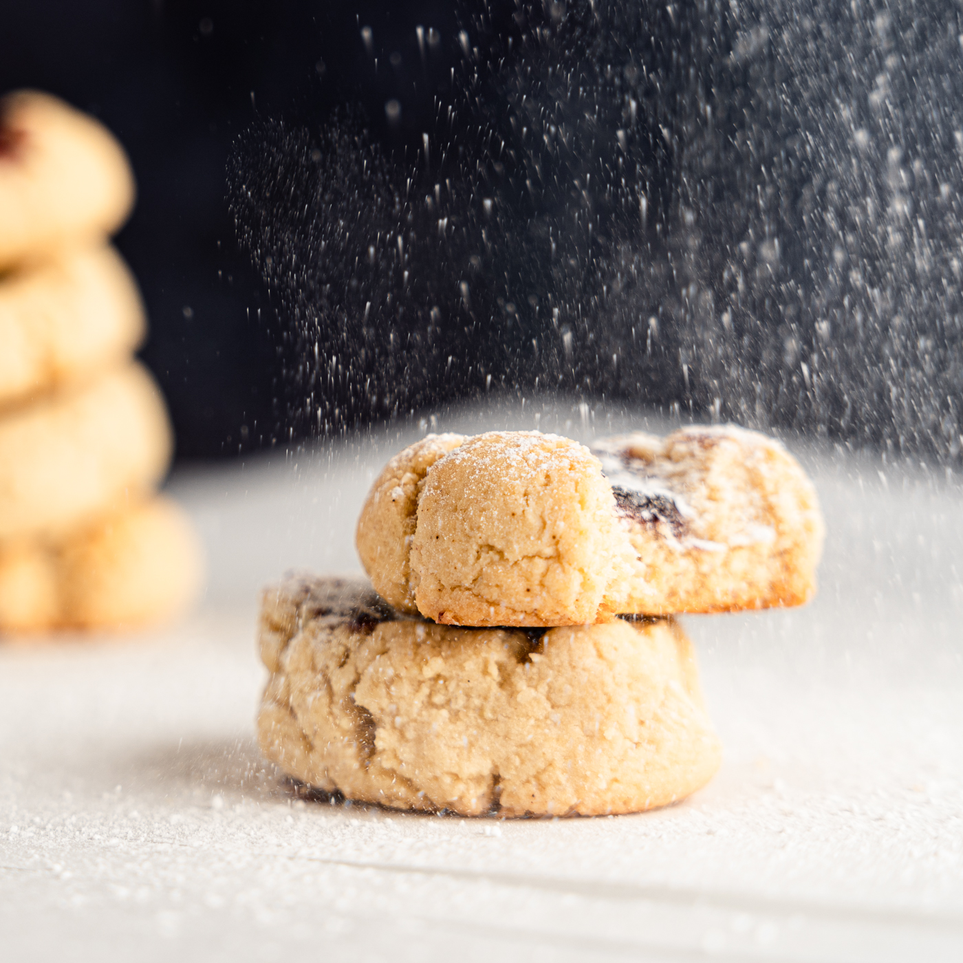 Powdered sugar dusting of an Almond Flour Thumbprint Cookie