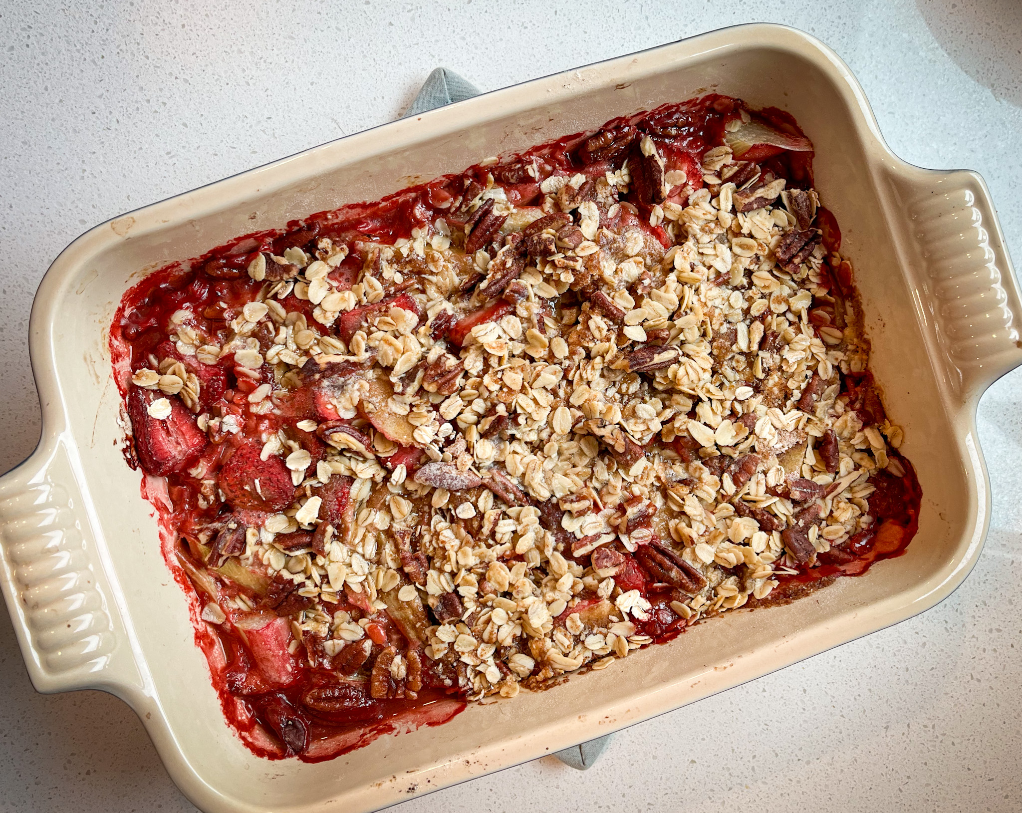 Strawberry Rhubarb Crisp in baking pan with a nut oat crispy topping
