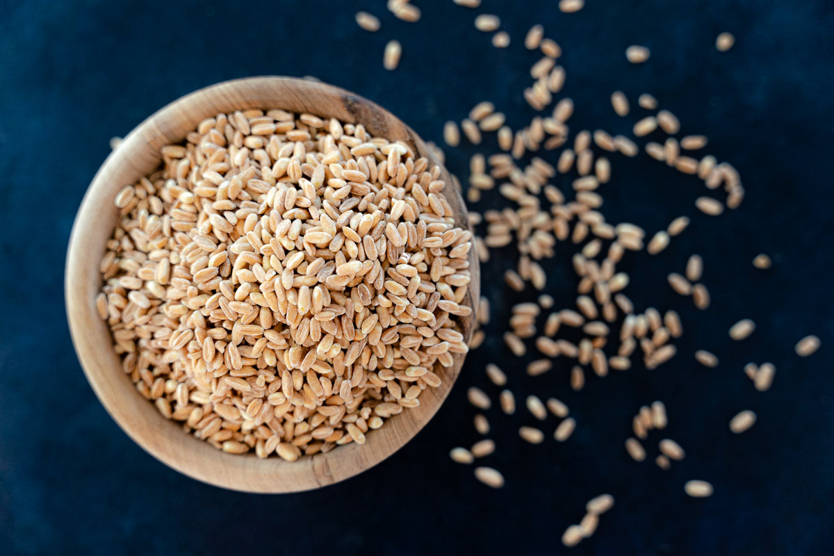 uncooked farro in a wooden bowl