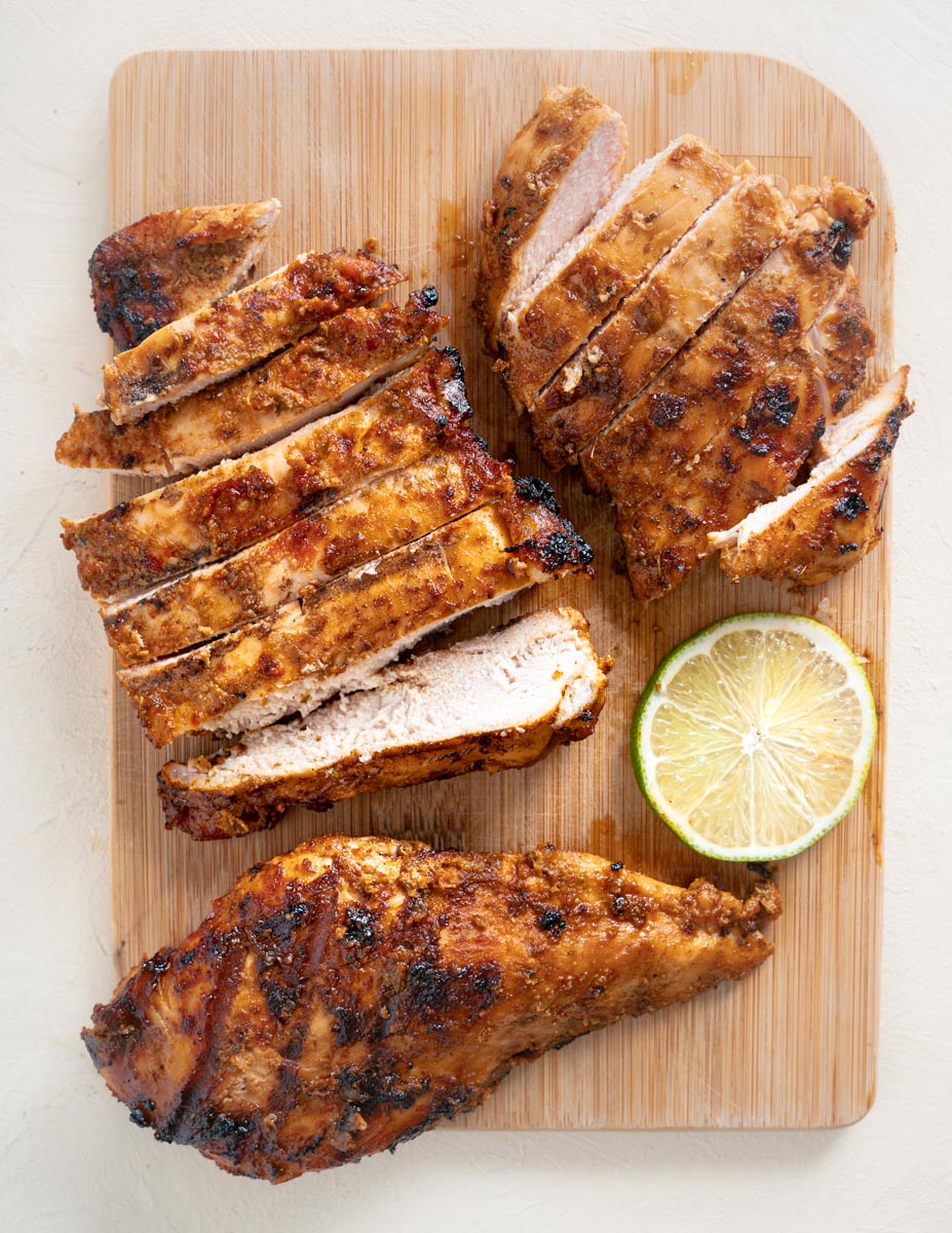 Sliced Southwest Grilled Chicken on a cutting board next to a slice of lime.