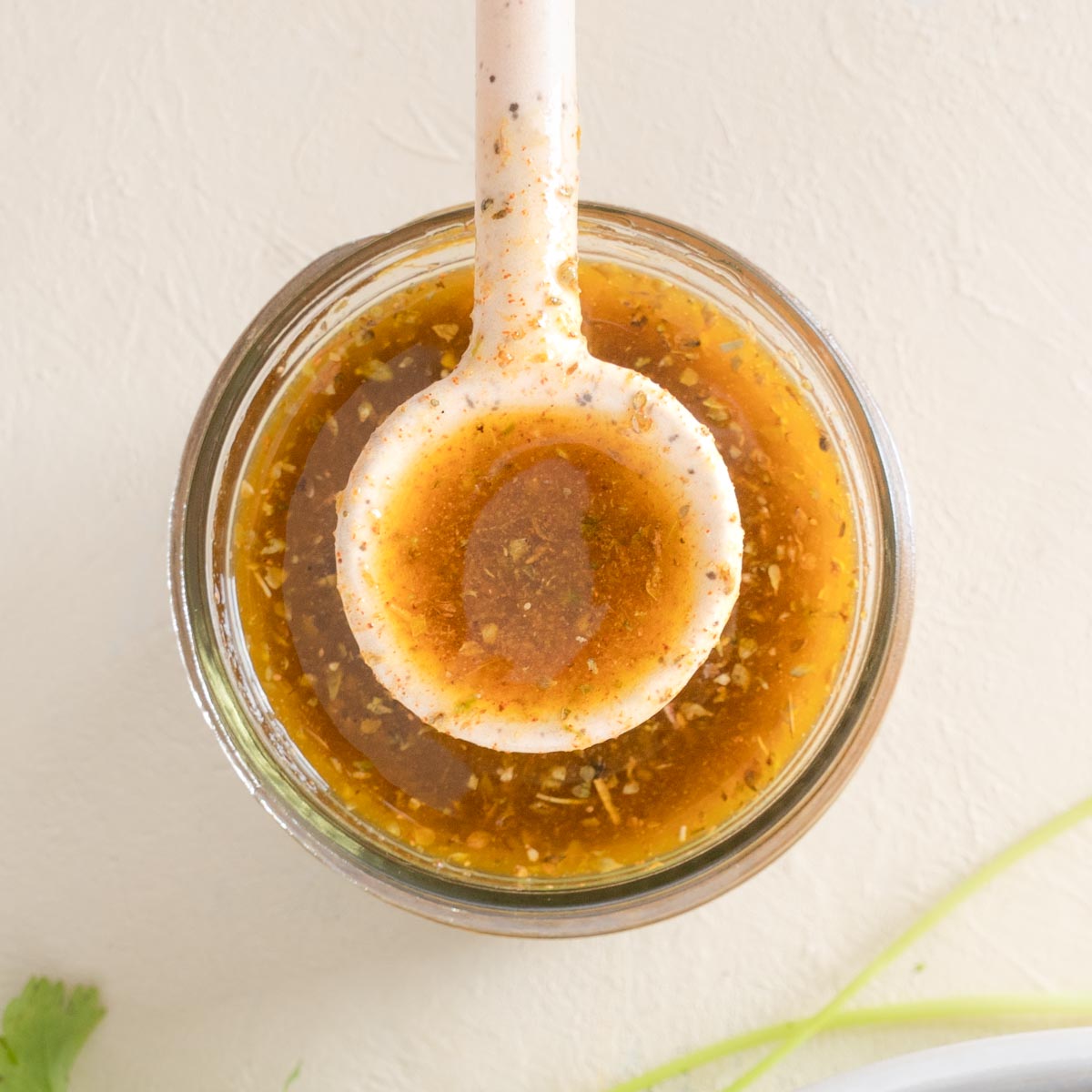 Southwest Vinaigrette in a glass jar with a speckled off white spoon