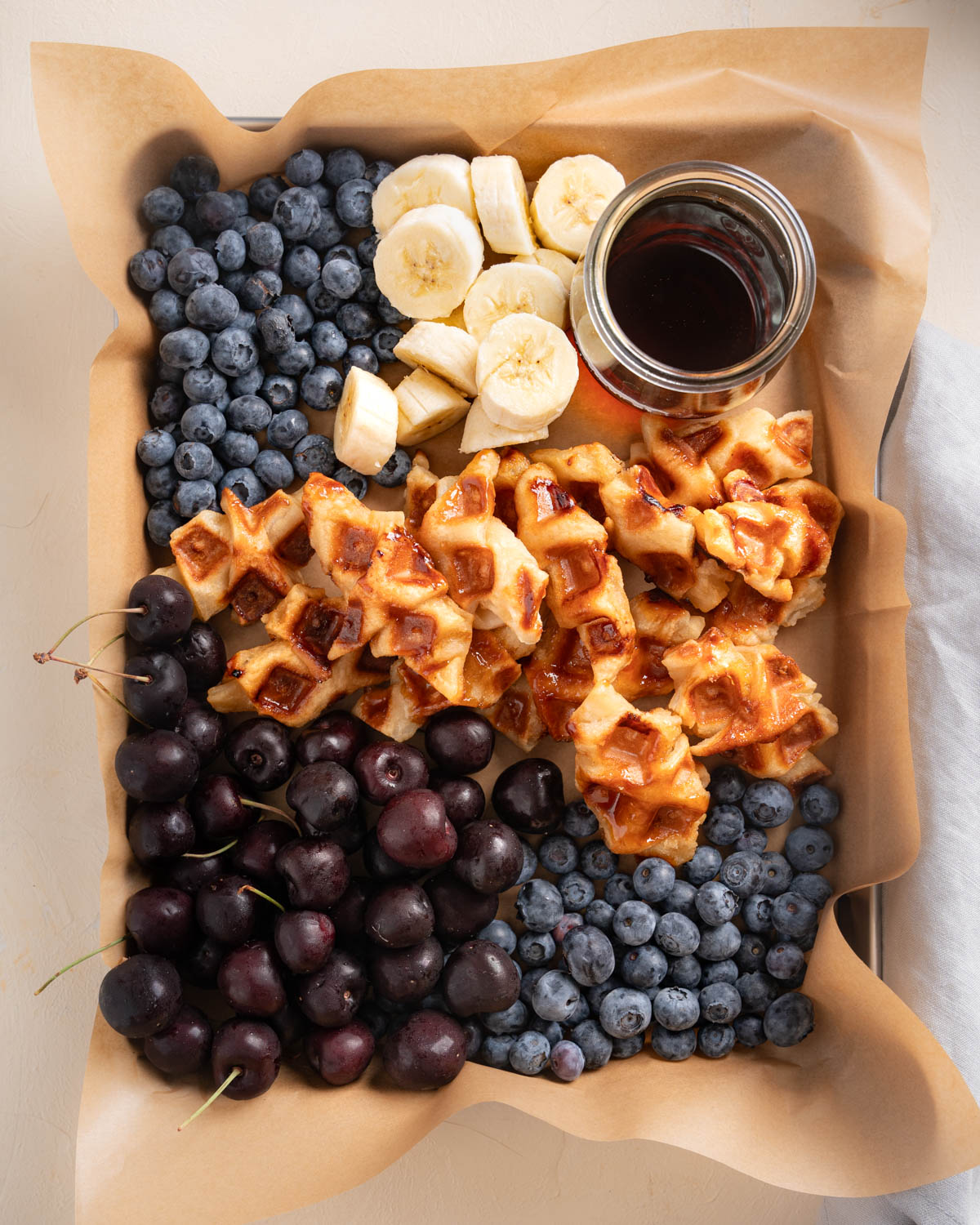 A Platter of croffles. In the platter are the croissant waffles, fresh fruit, and syrup. 