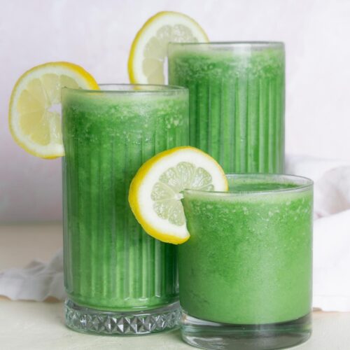 Green Morning Juice Smoothie with 3 classes of carrying heights. Garnished with a lemon slice.