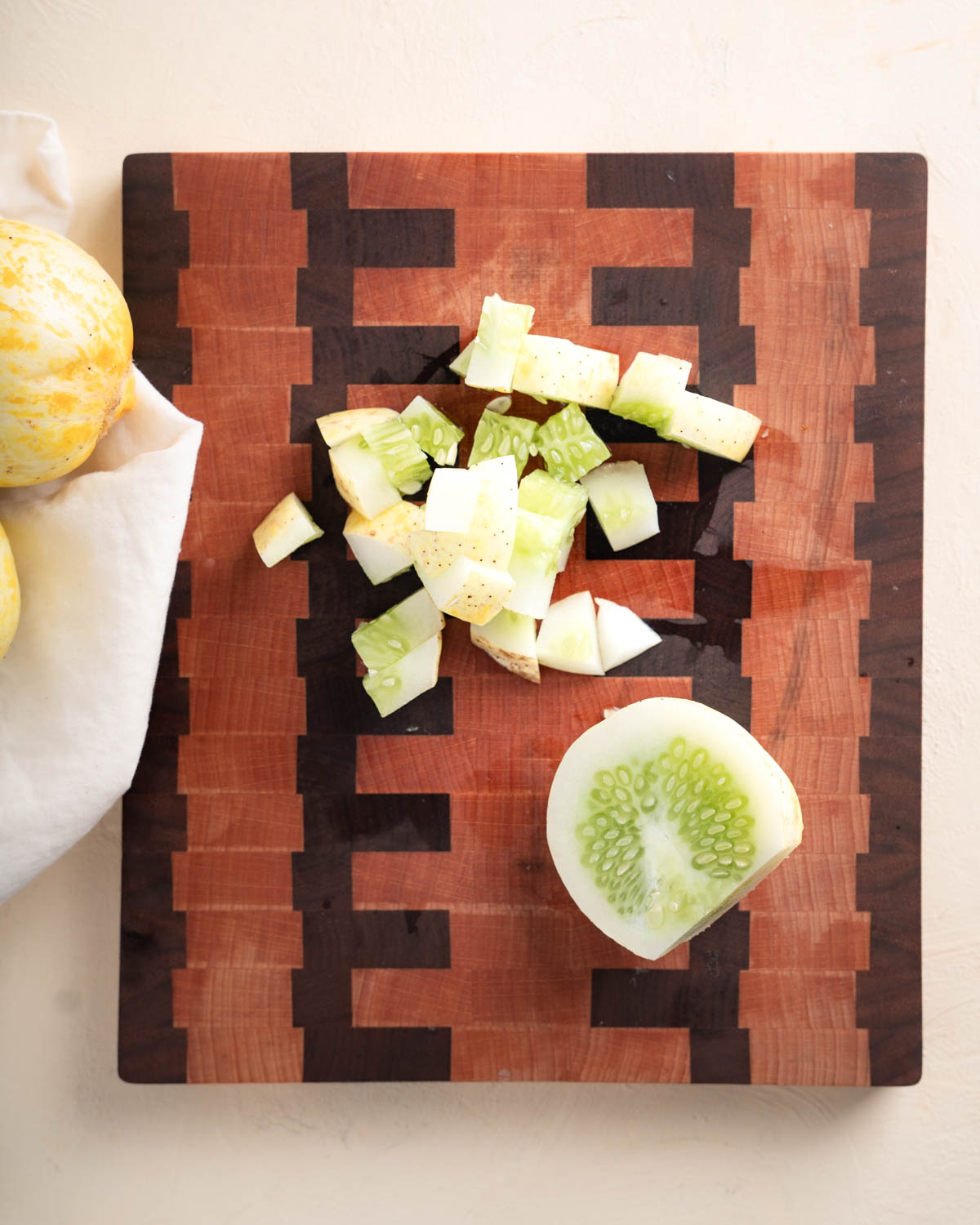 Diced yellow lemon cucumber in a cutting board. 