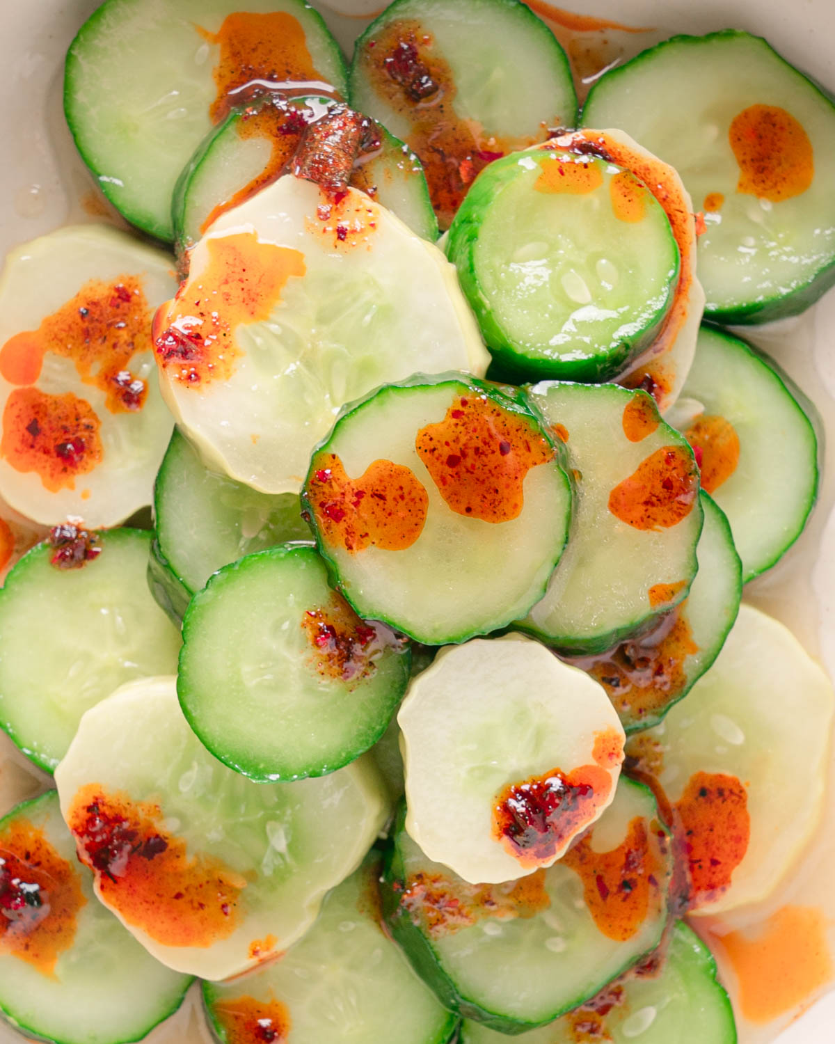 Close up of Din Tai Fung Cucumber Salad Recipe with a chili oil drizzle. 