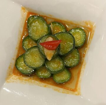Din Tai Fung Cucumber Recipe plated from the restaurant. The cucumbers are stacked with marinade all around. 