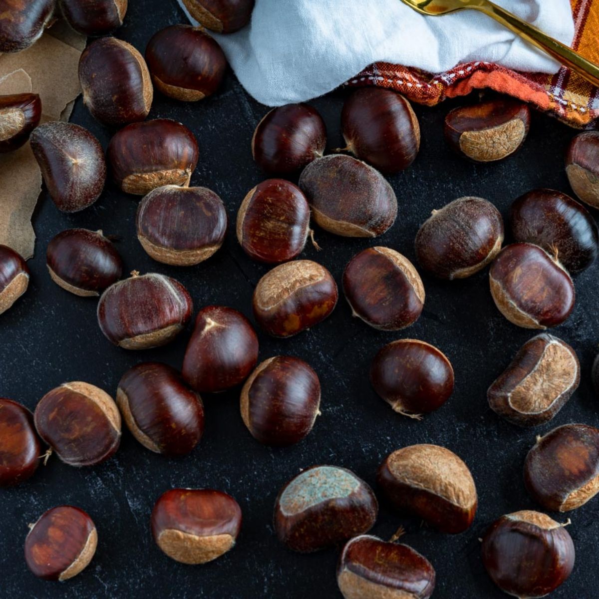 whole brown chestnuts with a orange checkered linin to the top of the image