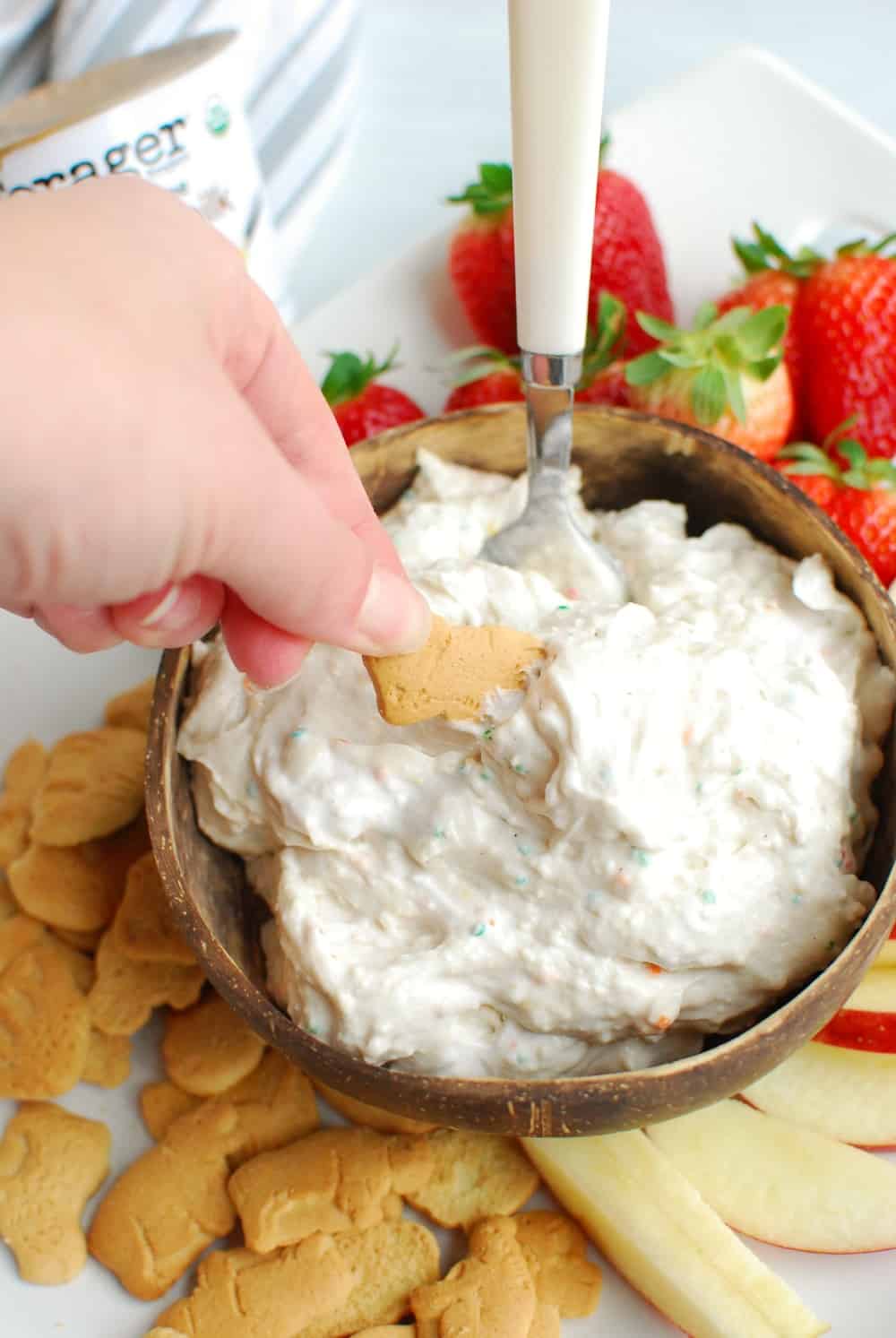 Cake Dip in a wooden bowl surrounded with cookies and berries. 