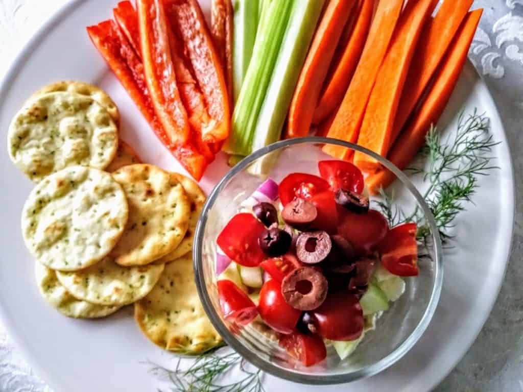 Layered Hummus Dip with veggie and cracker dippers. 