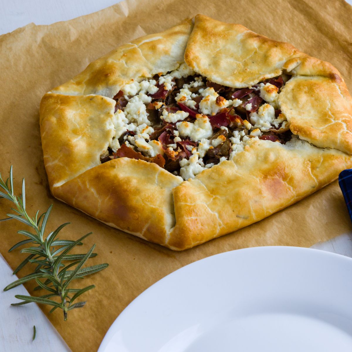 Oyster Mushroom galette with cheese and a golden crust laid upon brown parchment paper