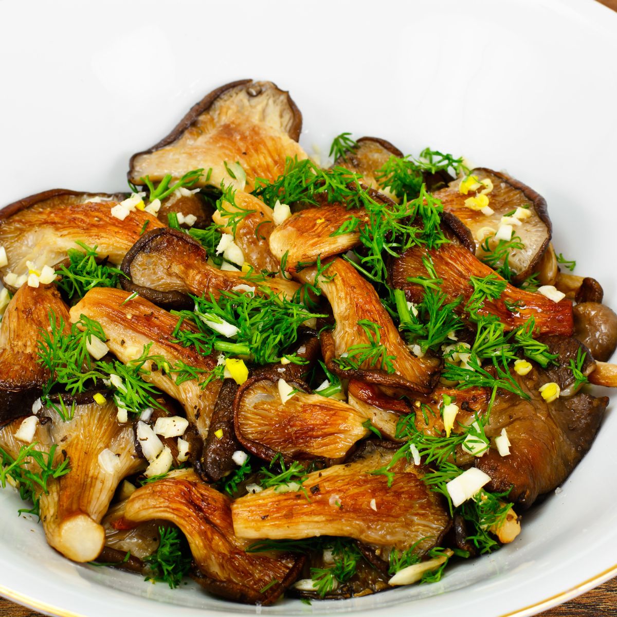 Sauteed Pink Oyster Mushrooms in a white bowl garnished with herbs