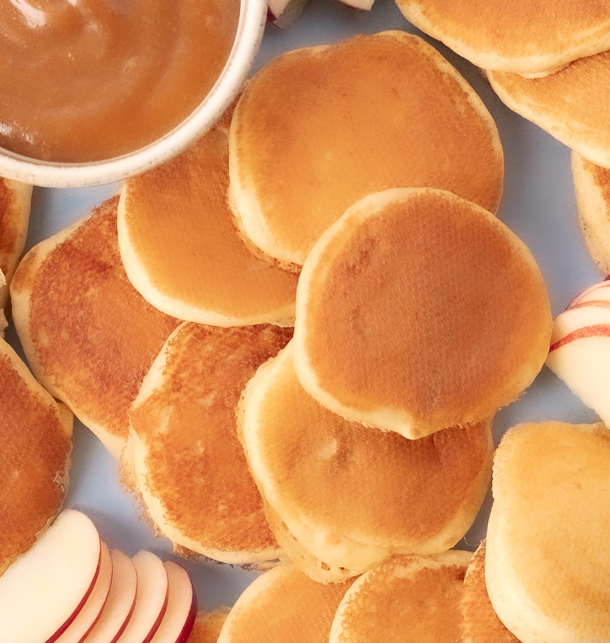 closeup of mini sweet cream pancakes on a blue plate