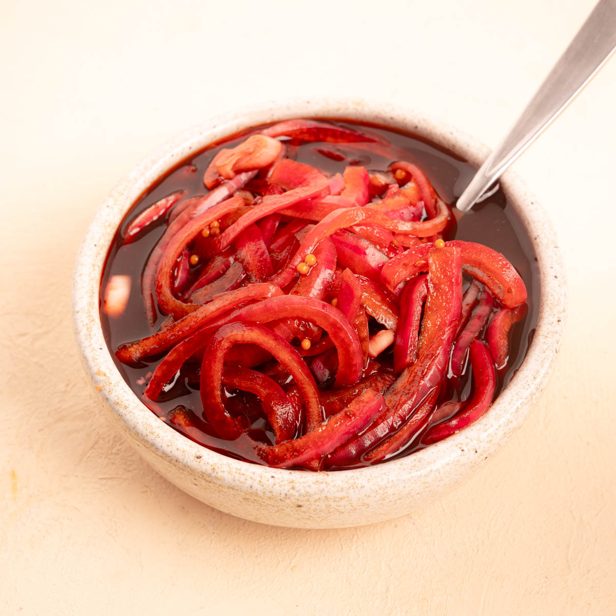 Balsamic Pickled Onions in a bowl with a spoon 