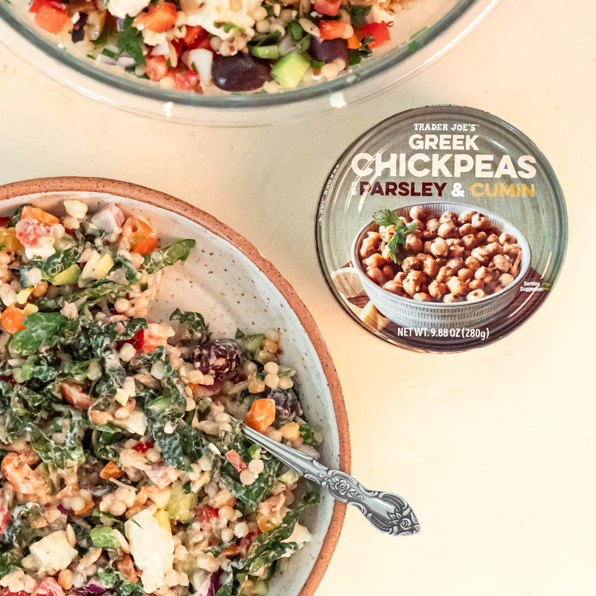 Trader Joe's Greek Chickpeas next to two bowls with greek grain bowls using Trader Joe's Harvest Blend