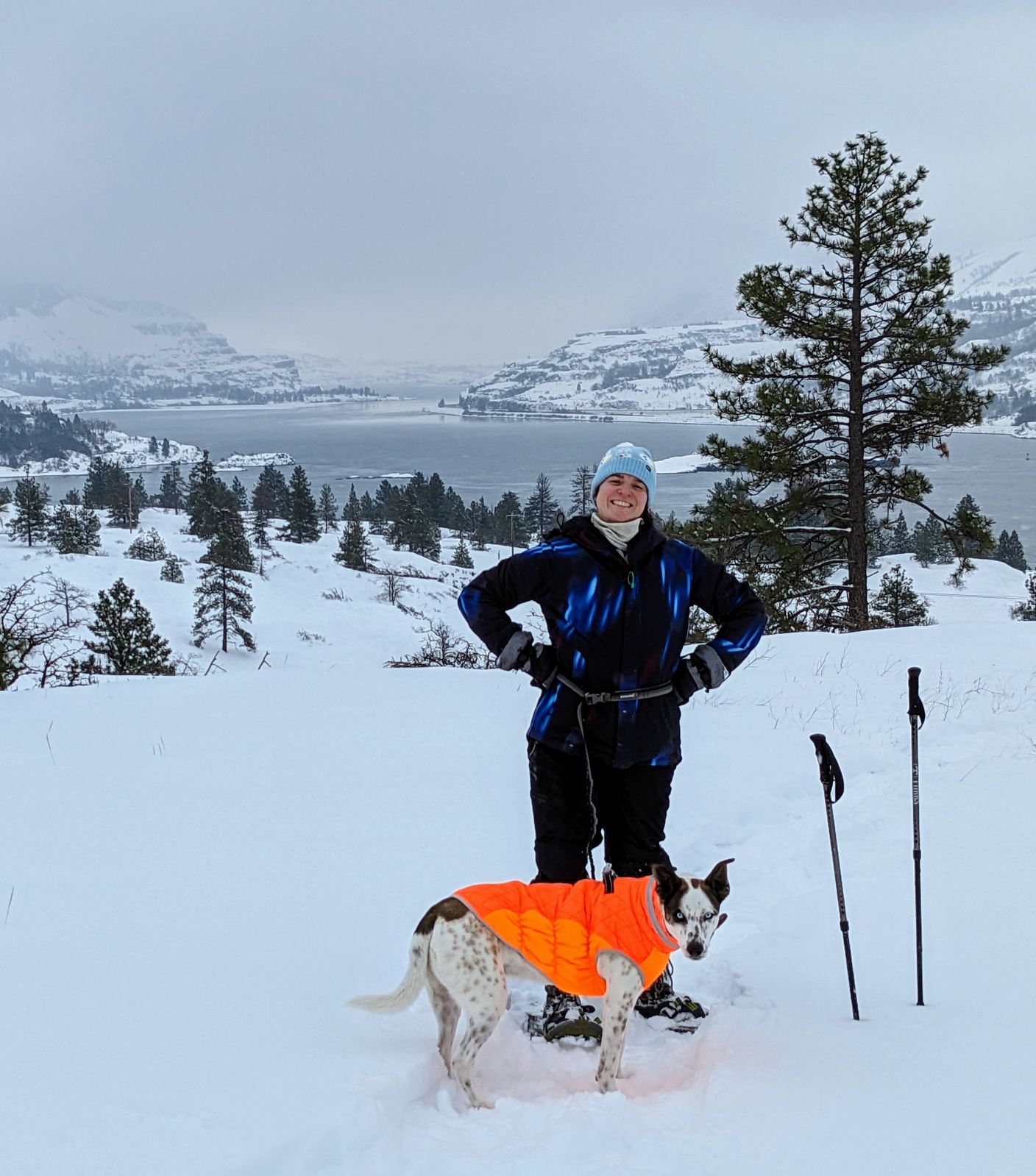 Sarah Harper in the snow in the Pacific Northwest with her dog in a bright orange snow vest