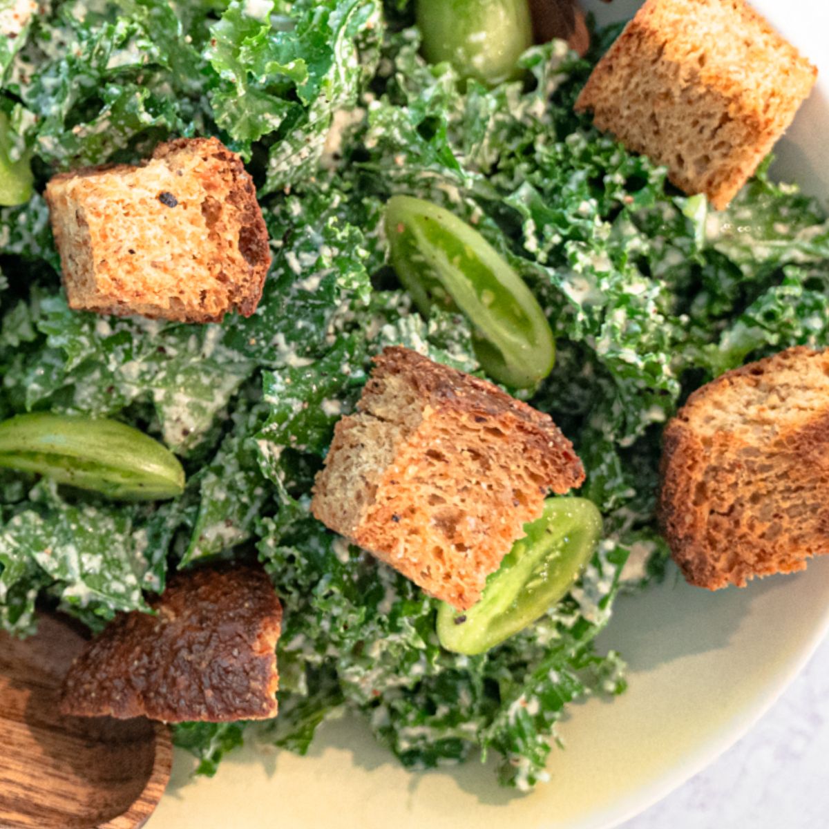 vegan croutons on a vegan caesar salad with green tomatoes and kale