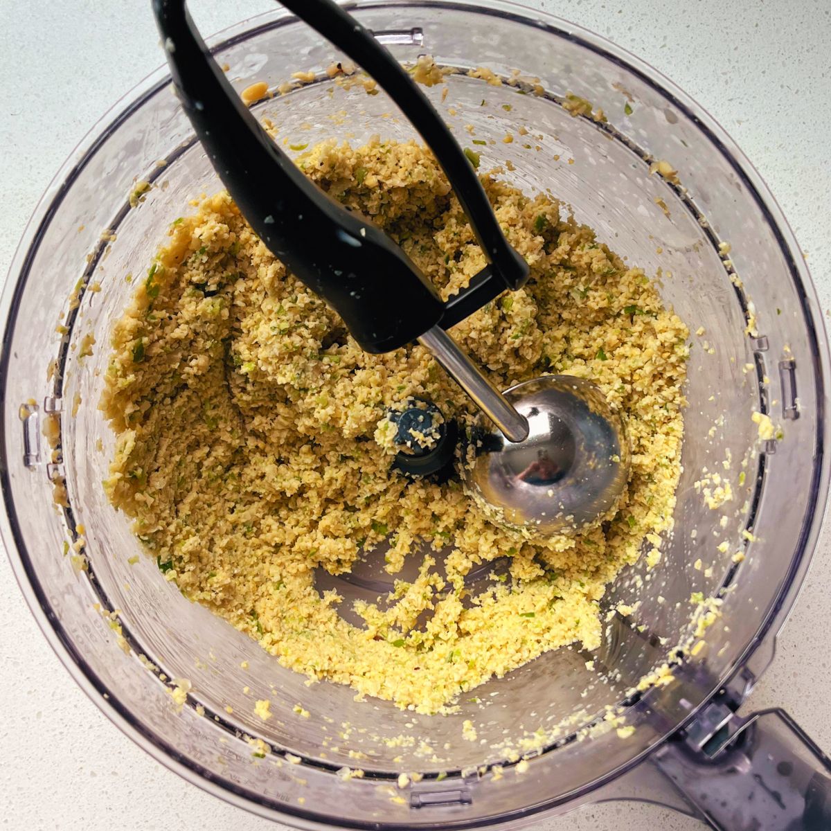 prepared mixture of falafel in a food processor with scoop